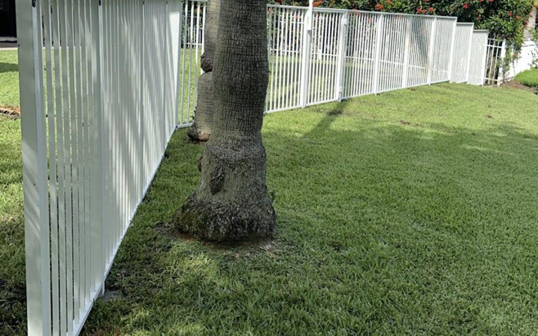White mechanical aluminum fence installed on a residential property in Weston, Broward County, FL, by Exclusive Custom Fence & Repairs.