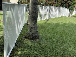 White mechanical aluminum fence installed on a residential property in Weston, Broward County, FL, by Exclusive Custom Fence & Repairs.