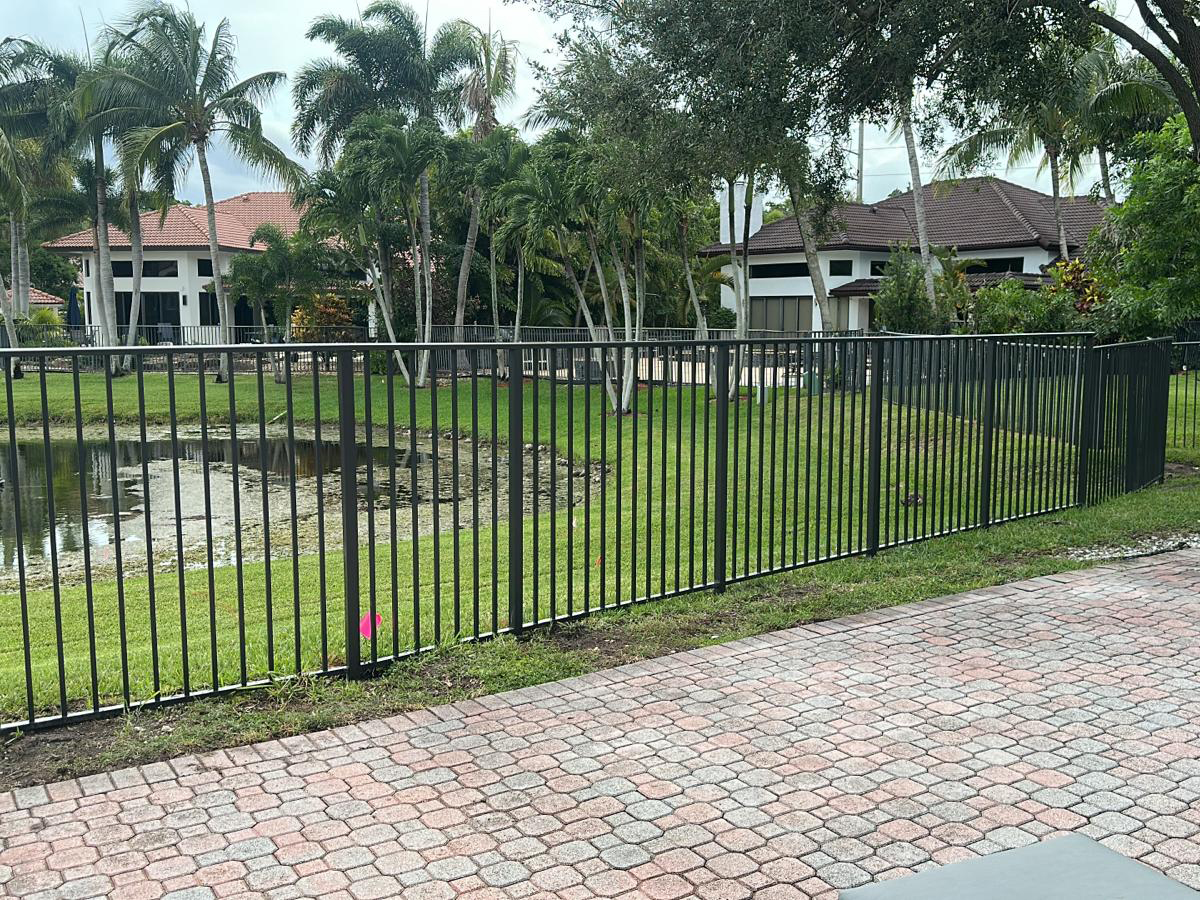 CF10 bronze mechanical aluminum fence installation along a waterfront property in Weston, Florida.